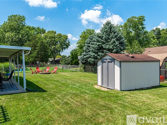 A backyard with a shed, a hot tub, and a lawn.