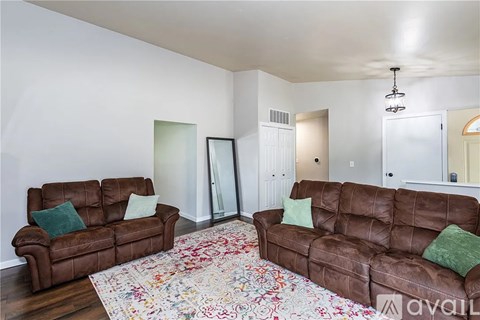 A living room with two brown couches and a floral rug.