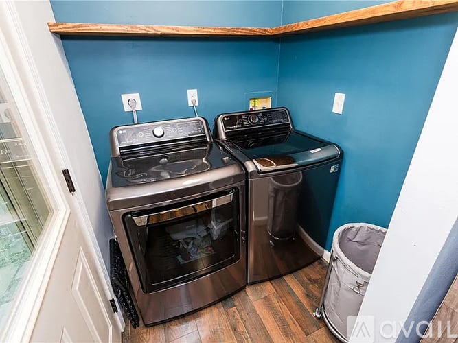 Two ovens and a trash can in a kitchen.