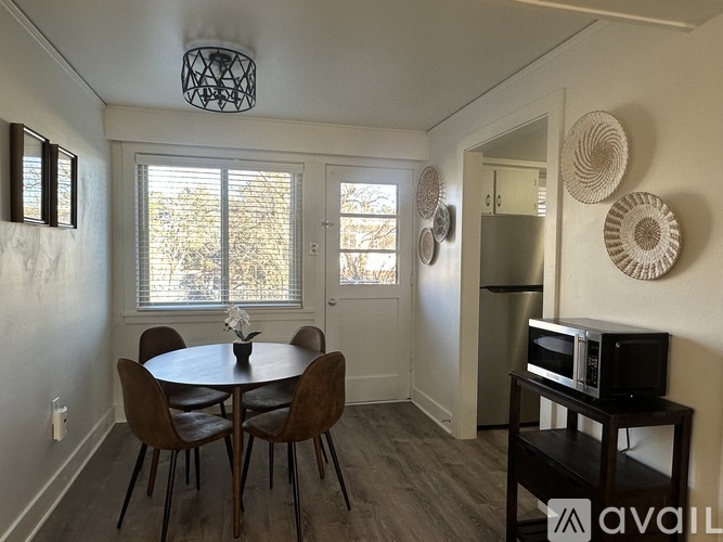 A dining room with a table and chairs.