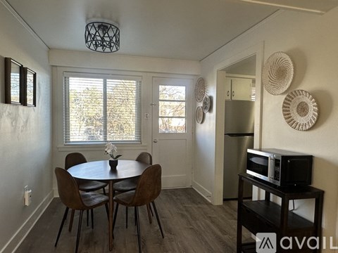 A dining room with a table and chairs.