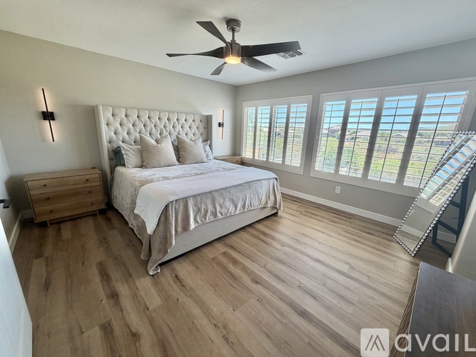 A bedroom with a large bed and a ceiling fan.