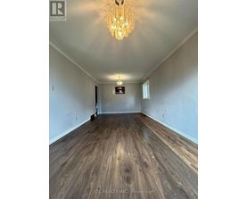 A room with wooden flooring and a chandelier.