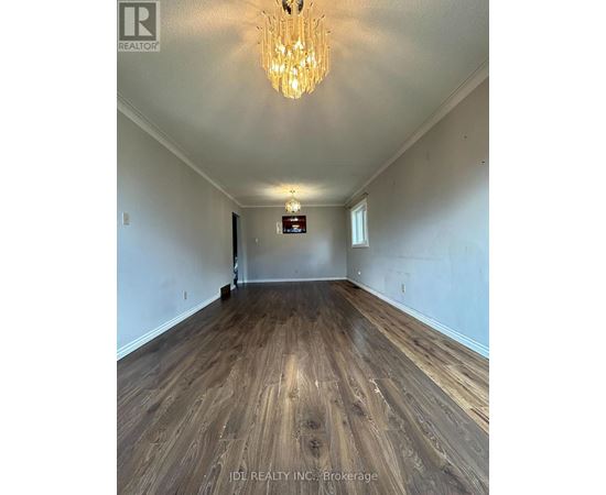 A room with wooden flooring and a chandelier.