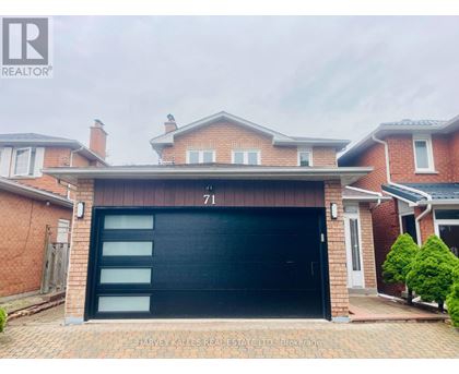 A brick house with a black garage door numbered 71.