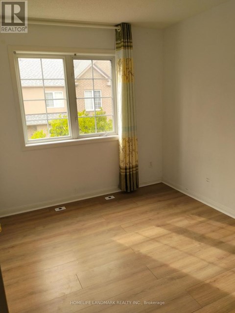 A room with a window and a curtain with a pattern on it.