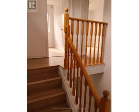 A wooden staircase with a white wall in the background.