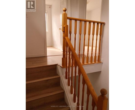 A wooden staircase with a white wall in the background.