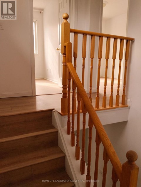 A wooden staircase with a white wall in the background.