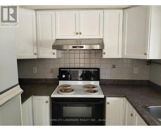 A kitchen with white cabinets and a black stove top.