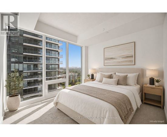 A bedroom with a large bed, a window with a view of a building, and a painting on the wall.