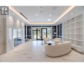 A spacious lobby with a white marble floor and a green exit sign above the door.