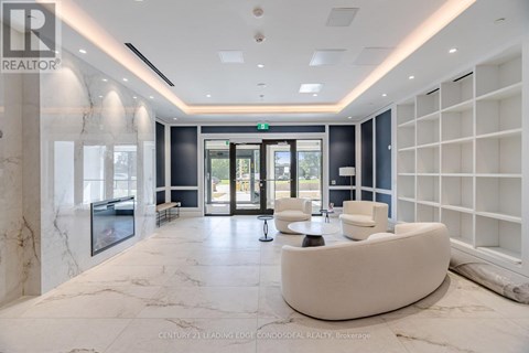 A spacious lobby with a white marble floor and a green exit sign above the door.