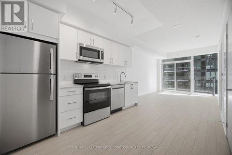 A modern kitchen with white cabinets and stainless steel appliances.