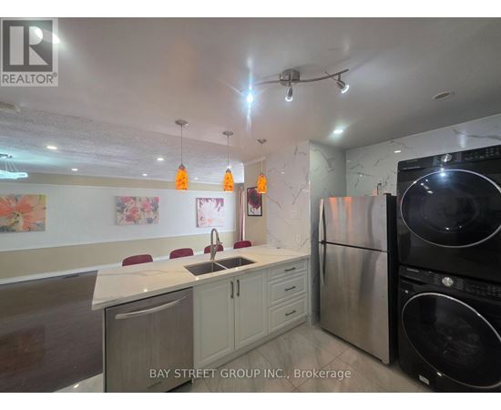 A kitchen with a white counter top and a black refrigerator.