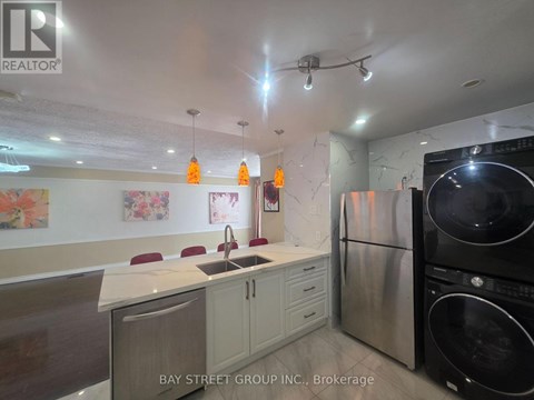 A kitchen with a white counter top and a black refrigerator.
