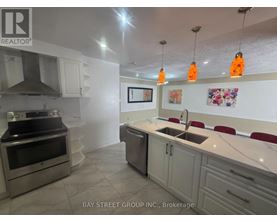A kitchen with a sink, stove, and cabinets.