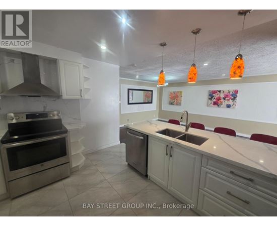 A kitchen with a sink, stove, and cabinets.