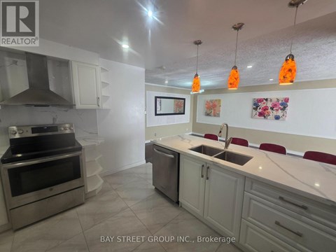 A kitchen with a sink, stove, and cabinets.