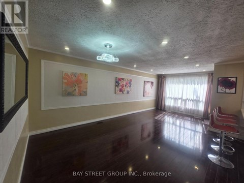 A room with a ceiling light and a painting on the wall.