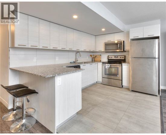 A modern kitchen with white cabinets and stainless steel appliances.