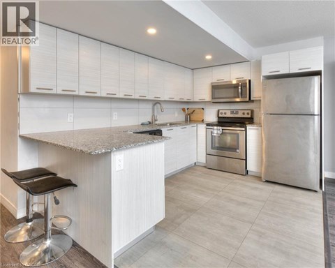 A modern kitchen with white cabinets and stainless steel appliances.