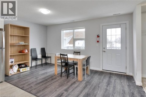 A dining room with a table and chairs.