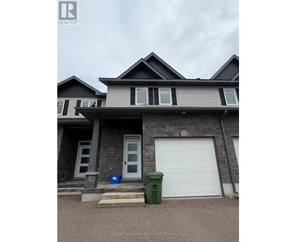 A house with a grey and black exterior and a white garage door.