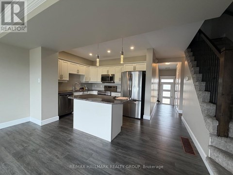 A spacious kitchen with a stainless steel refrigerator and a modern design.