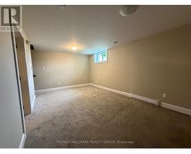 A room with a carpeted floor and a window with a cross on it.