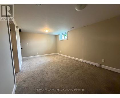 A room with a carpeted floor and a window with a cross on it.
