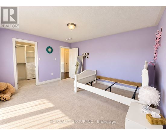 A bedroom with purple walls and a white bed.