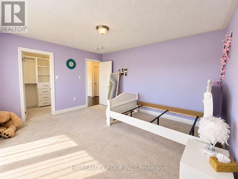 A bedroom with purple walls and a white bed.