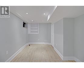 A spacious room with wooden flooring and white walls, ready for furnishing.