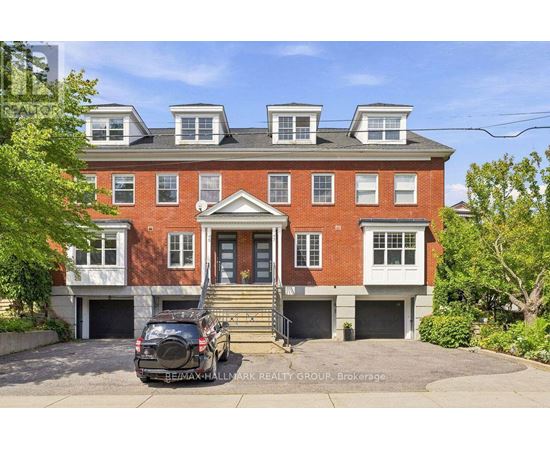 A red brick house with a black car parked in front.