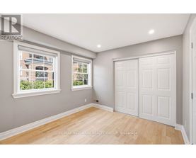 A room with a white door and a window with a view of a building outside.