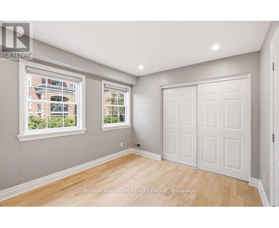 A room with a white door and a window with a view of a building outside.