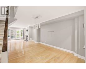 A spacious room with wooden flooring and white walls.
