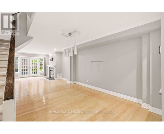 A spacious room with wooden flooring and white walls.