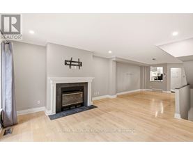 A spacious living room with a fireplace and hardwood floors.
