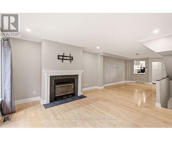 A spacious living room with a fireplace and hardwood floors.