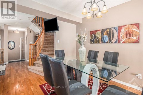 A modern dining room with a glass table and chairs.