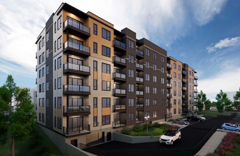 A modern apartment building with a parking lot in front.