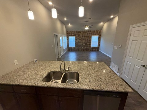 A kitchen with granite countertops and a brick wall in the background.