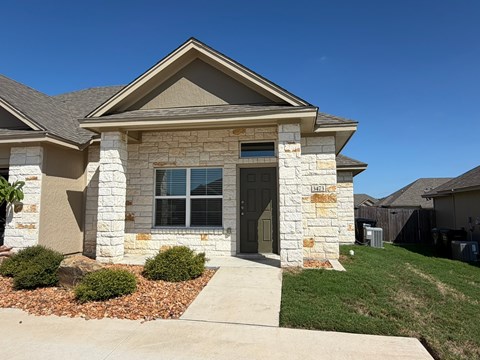 A house with a brown roof and a grey front door.