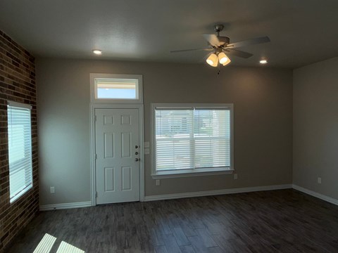 A room with a ceiling fan and a door.