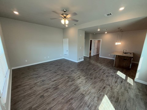 A room with wood flooring and a ceiling fan.