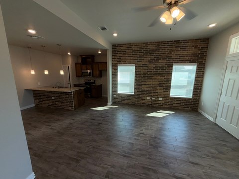 A room with a brick wall and a ceiling fan.