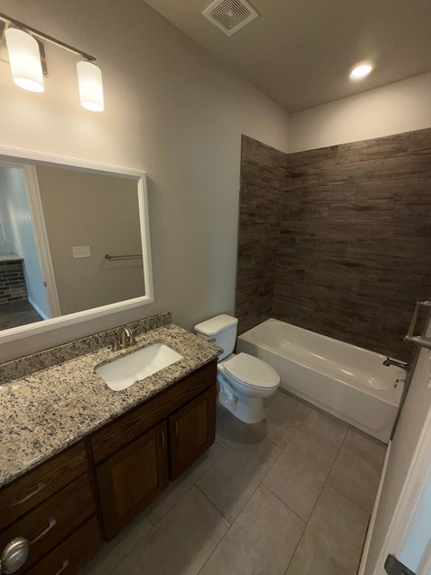 A bathroom with a sink, toilet, and bathtub.