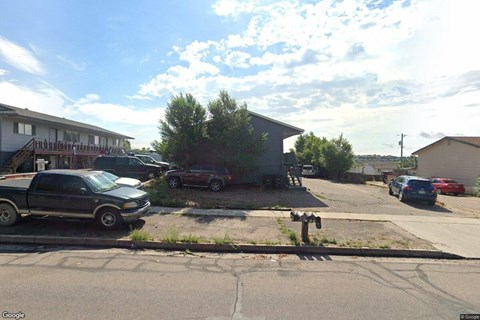 A street view with cars parked on the side of the road.